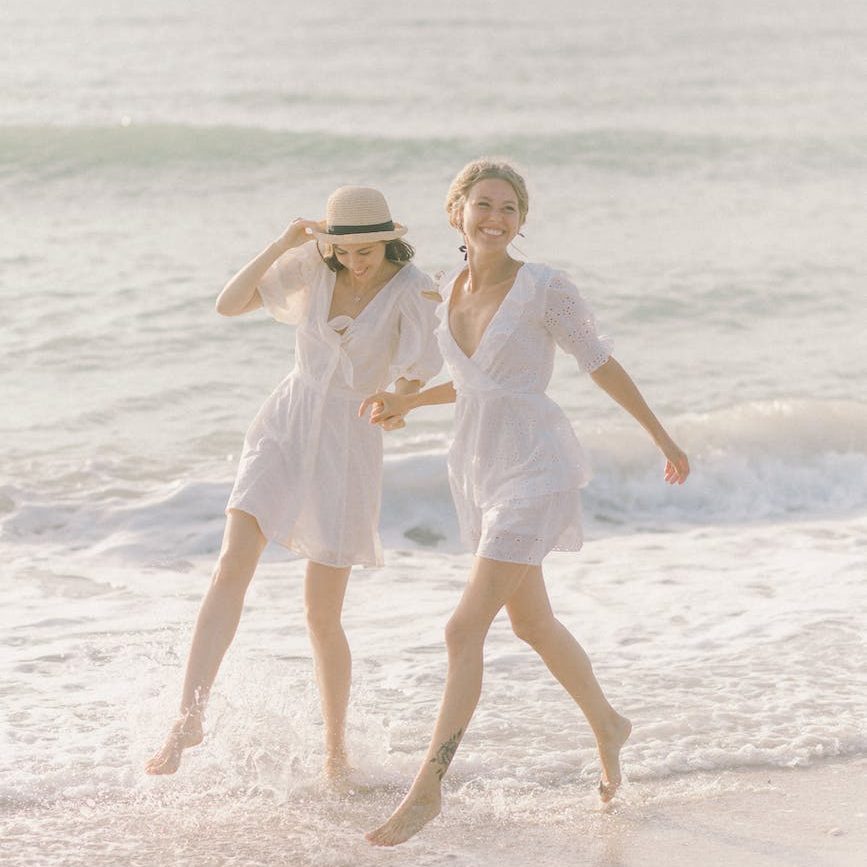 couple holding hands while on the beach